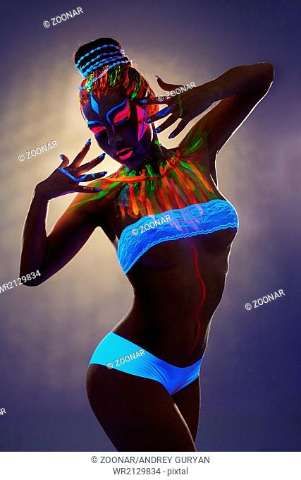 Seductive female dancer with luminous body art