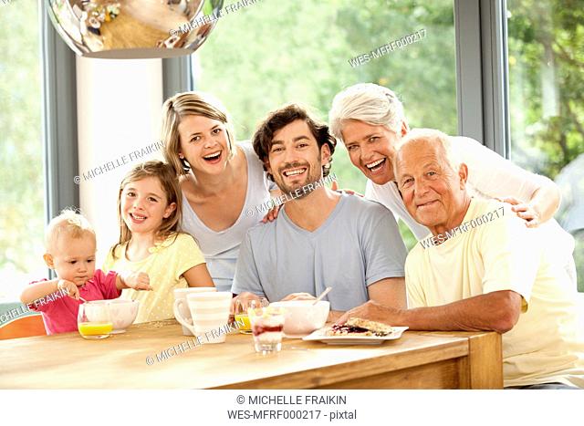 Portrait of happy extended family at breakfast table