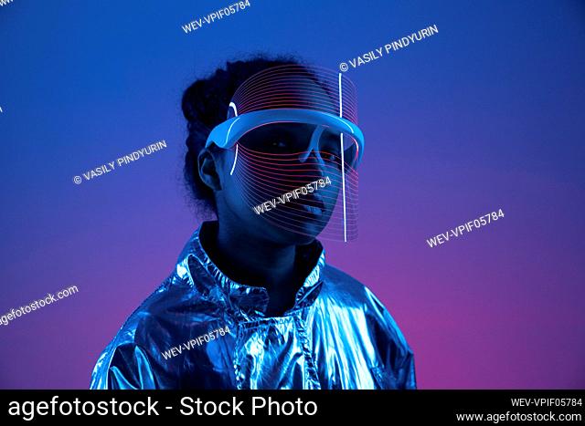 Woman wearing futuristic smart glasses against multi-colored background