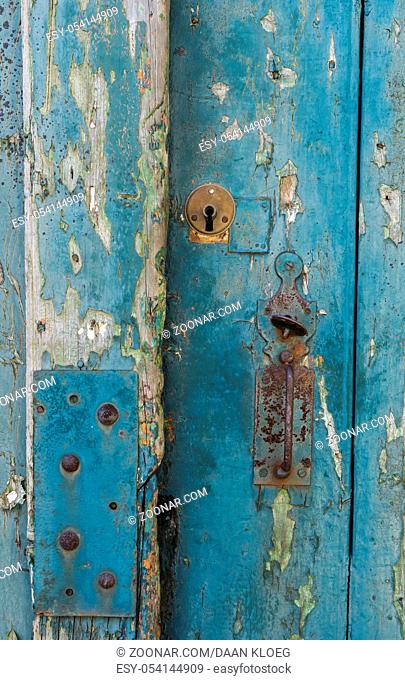Old iron handle on a blue wooden door in Sancerre in France