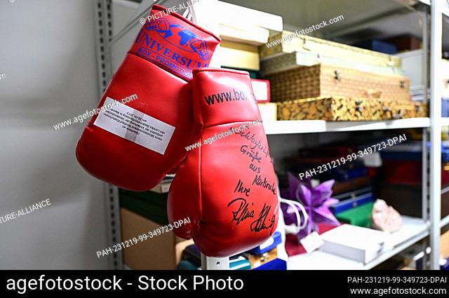 PRODUCTION - 18 December 2023, Baden-Württemberg, Stuttgart: Boxing gloves from former boxer Halmich, which she donated to the Baden-Württemberg state...
