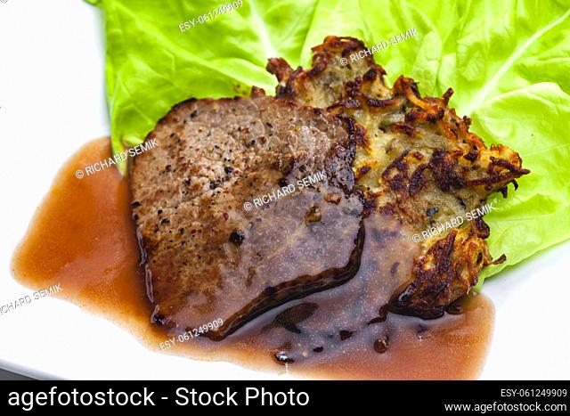 beef steak with sauce served with potato pankcakes