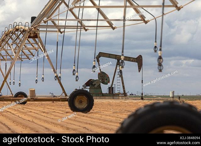 Plains, Texas - An oil well near irrigation equipment on farm land in the Permian Basin