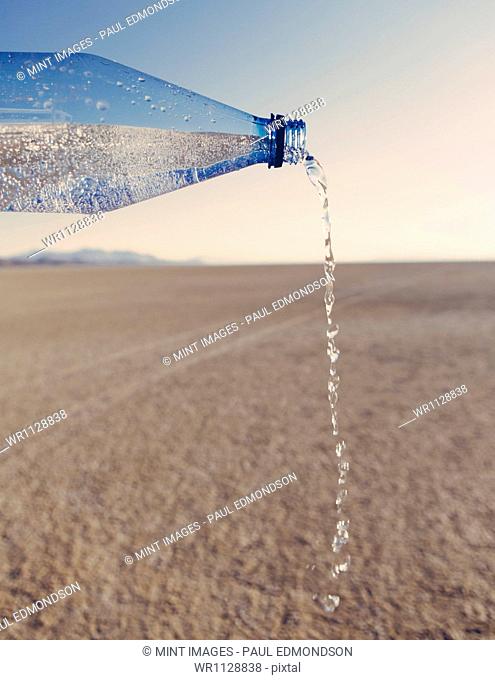 The landscape of the Black Rock Desert in Nevada. An essential element for survival. A bottle of water being poured out. Filtered mineral water