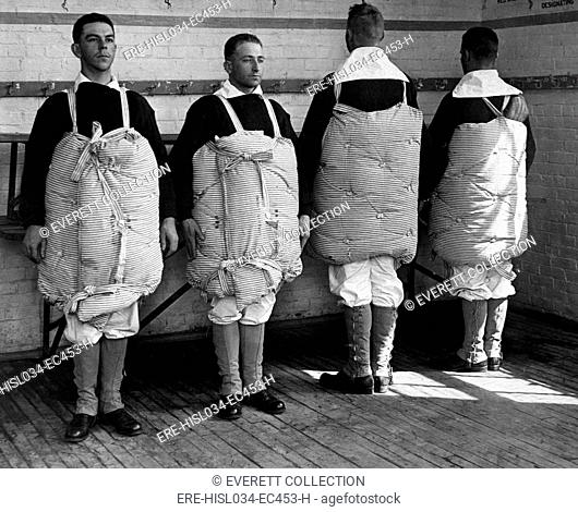 Navy recruits with their mattresses tied to them to serve as life preservers. Newport Naval Training Station, Rhode Island. World War I. April 1917