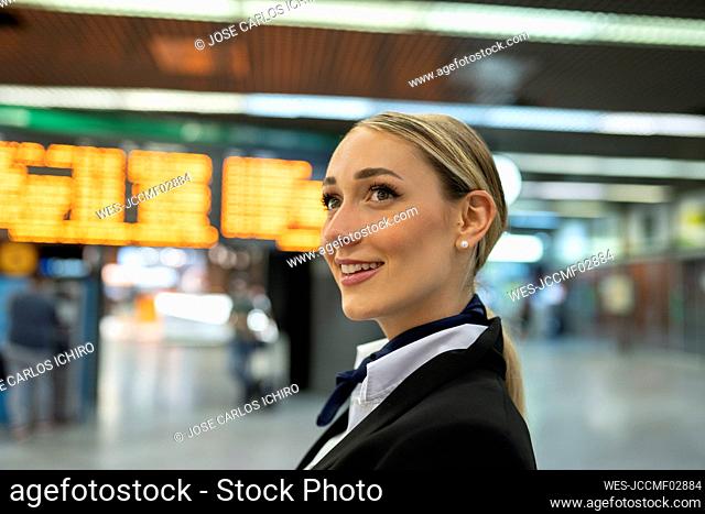 Thoughtful female flight attendant looking away at airport