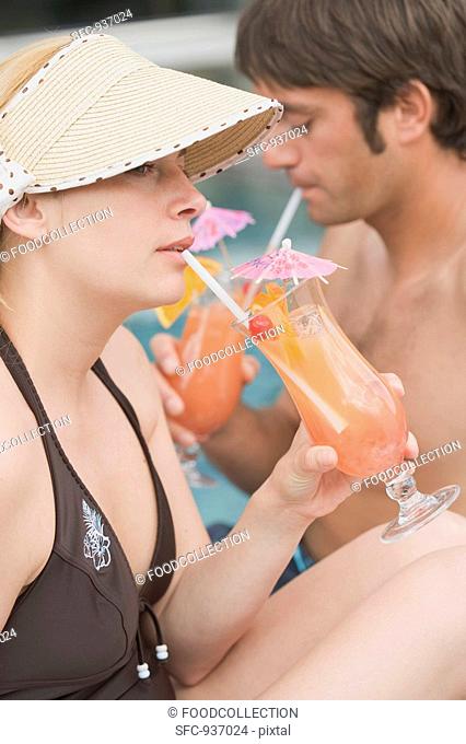 Man and woman drinking Planter's Punch by pool