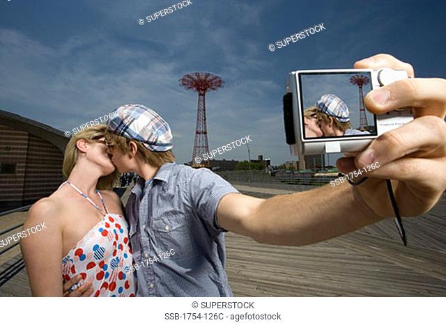 Young couple taking a photograph with a digital camera, Parachute Drop, Coney Island, New York City, New York, USA