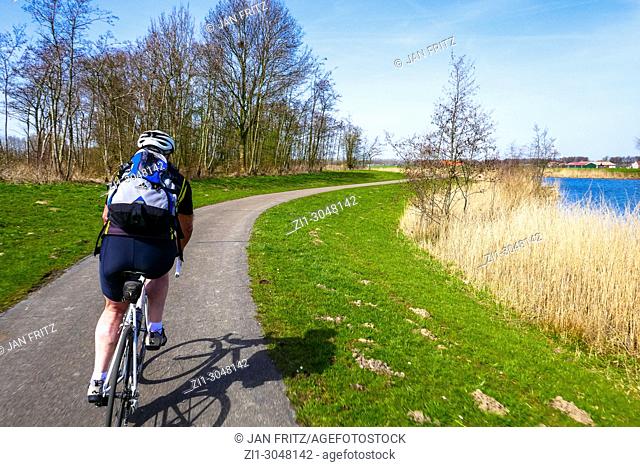 amateur race cyclist at small road in Hoeksche Waard, Holland