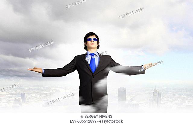 Image of powerful businessman standing against urban scenics