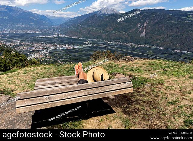 Senior woman wearing hat relaxing on bench