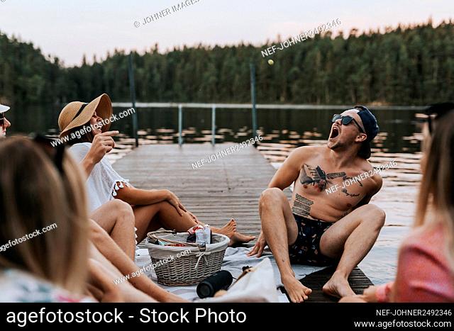 Happy friends sitting on jetty