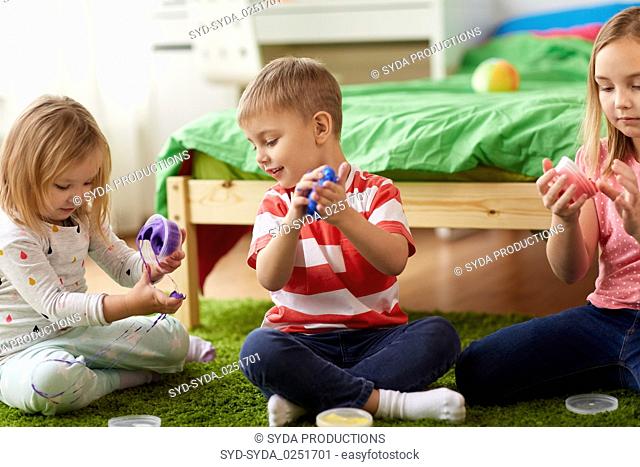 little kids with modelling clay or slimes at home