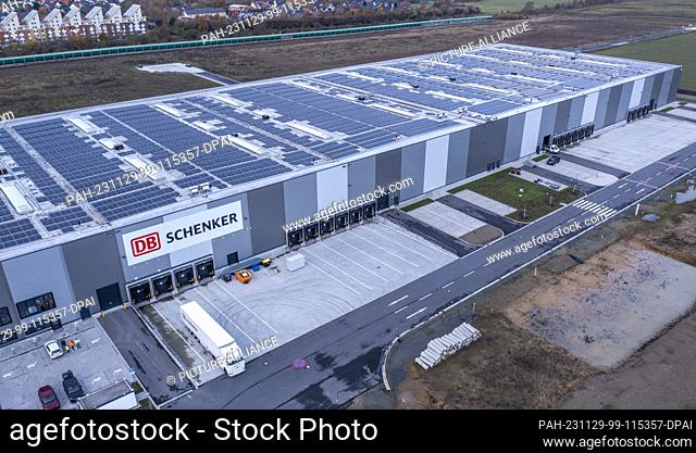 PRODUCTION - 21 November 2023, Mecklenburg-Western Pomerania, Rostock: A truck stands in front of the building with the new high-bay warehouse of the logistics...
