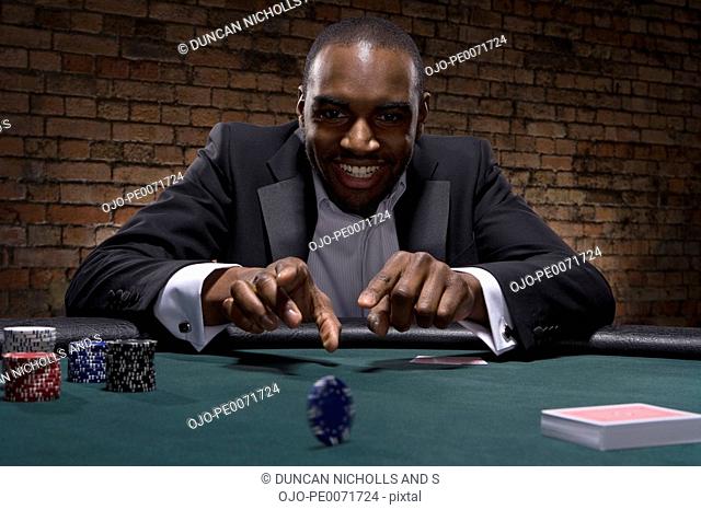 Man rolling poker chip in casino