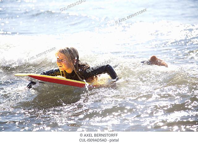 Portrait of girl on surfboard, Wales, UK
