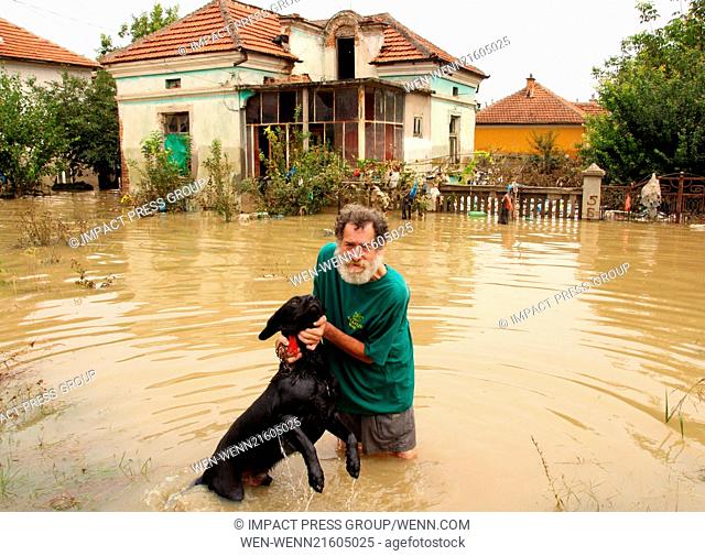 People try to save belongings, animals and pets in the flooded town of Mizia north-east of the Bulgarian capital Sofia , Wednesday, Aug, 06, 2014