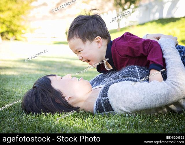 Happy chinese mother having fun with her mixed-race baby son