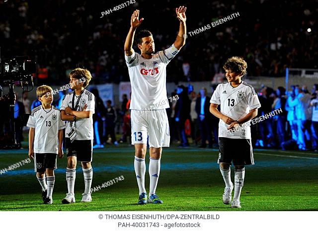 German soccer player Michael Ballack bids farewell to his fans with his three sons during his final soccer match at the Red Bull Arena in Leipzig, Germany