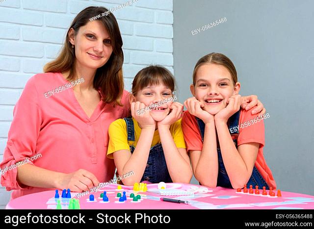 Portrait of a happy family playing board games at a table