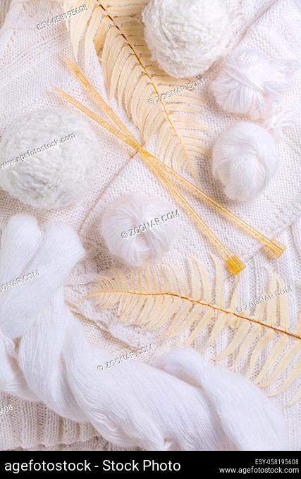 Knitting concept with needles, wool, sweater and yarn in white color