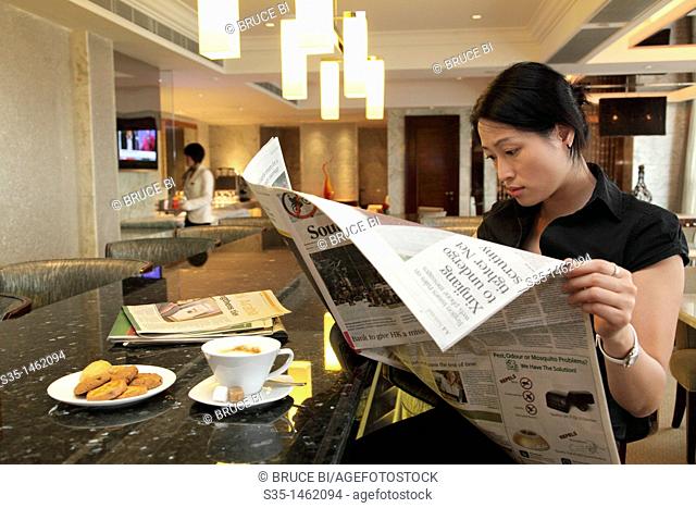 A young woman having her coffee break in the lounge of executive floors  Hotel Sofitel Macau at Ponte 16  Macau  China