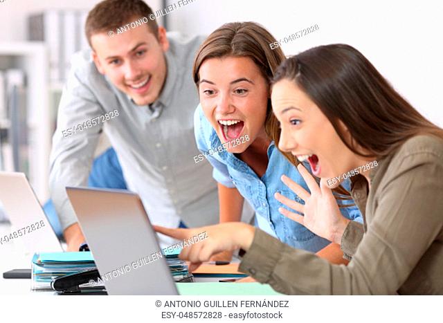 Three excited employees receiving good news on line at office