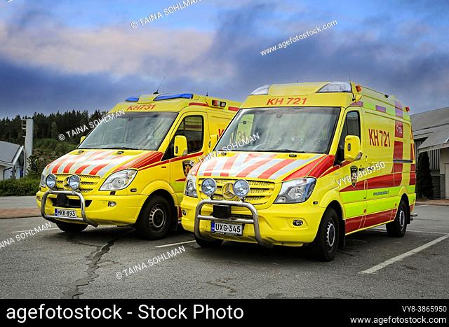Two Mercedes-Benz ambulance vehicles parked outside a service station. Finland