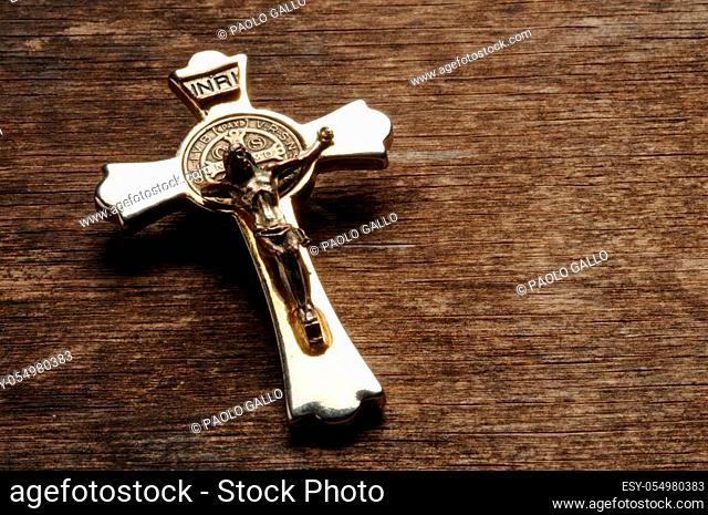 Metal crucifix on wooden background
