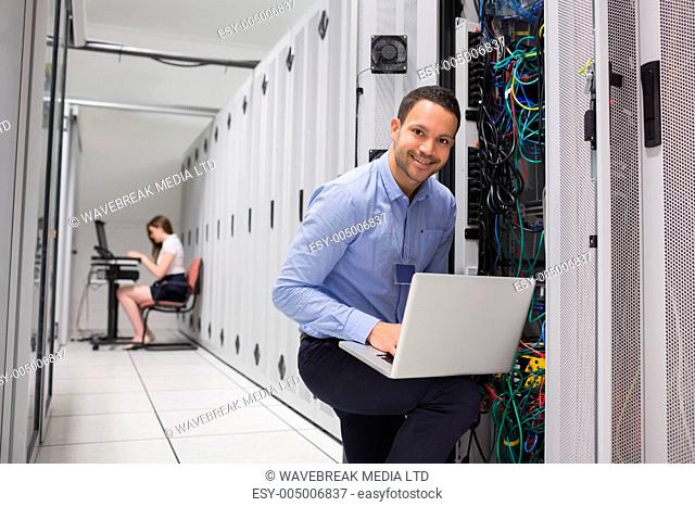 Two technicians doing data storage with their laptops