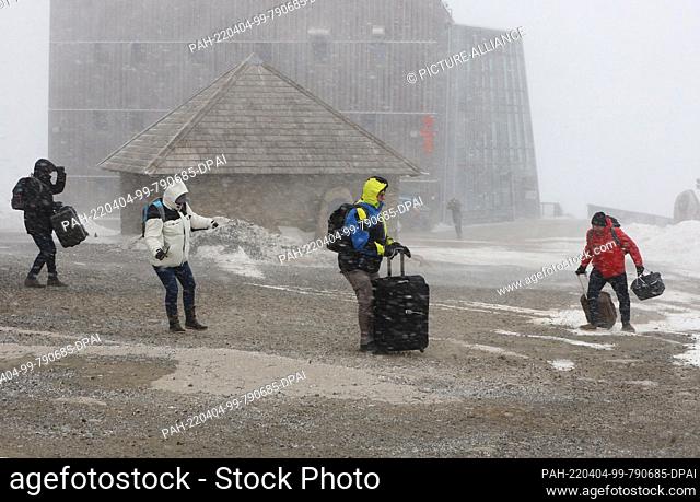 04 April 2022, Saxony-Anhalt, Schierke: Snow flurries and hurricane-like gusts of wind with speeds of up to 140 kilometers per hour sweep across the Brocken...