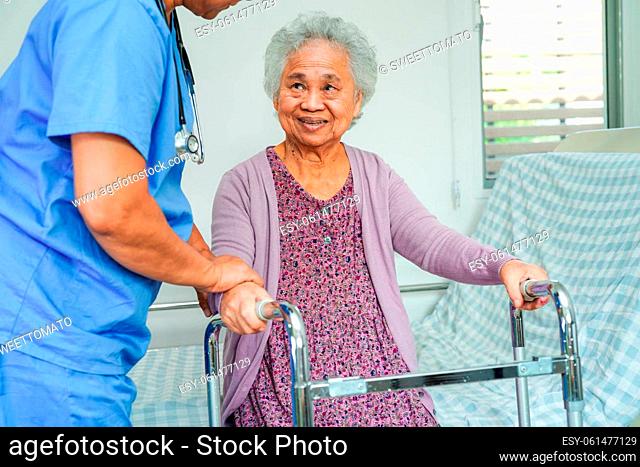 Doctor help Asian elderly woman disability patient walk with walker in nursing hospital, medical concept
