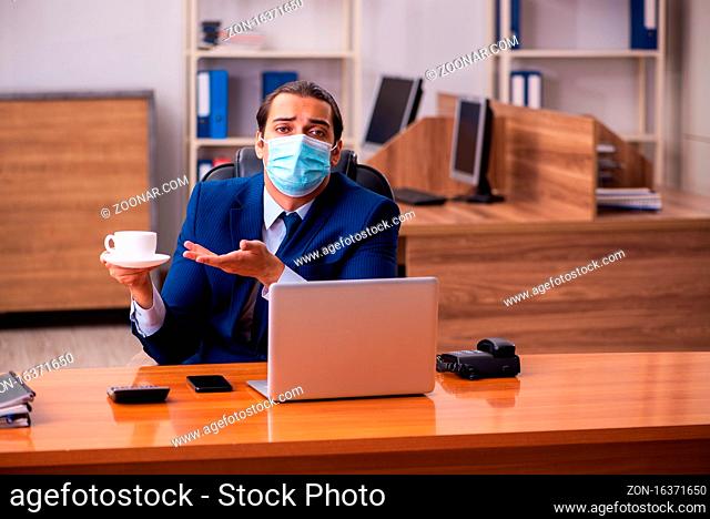 Young employee working in the office wearing mask