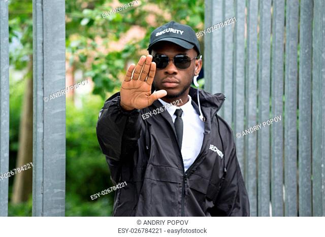 Confident Young African Male Security Guard Making Stop Gesture