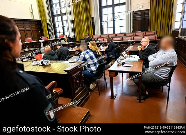 19 December 2023, Hamburg: The three defendants sit next to their lawyers in the courtroom before the start of the trial