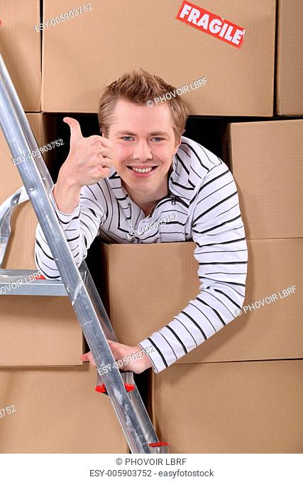 Factory worker emerging from cardboard boxes