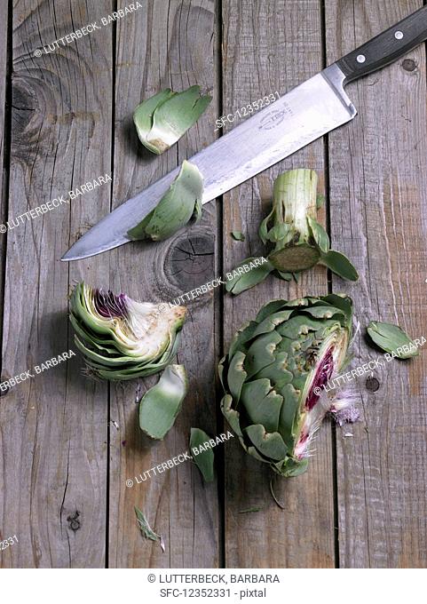 Chopped artichoke with a knife on a wooden background