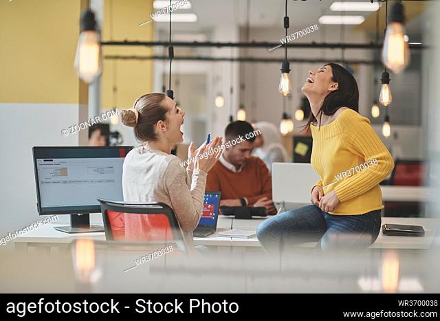office rumors with two girls whispering in coworking open space startup business office