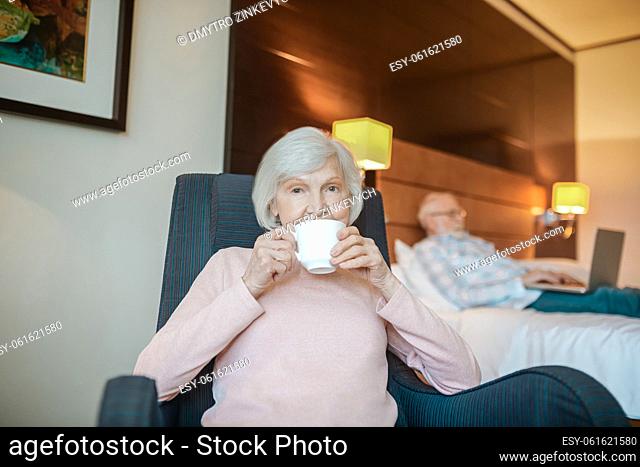 Coffee time. Pleasant-looking senior woman with a cup of coffee