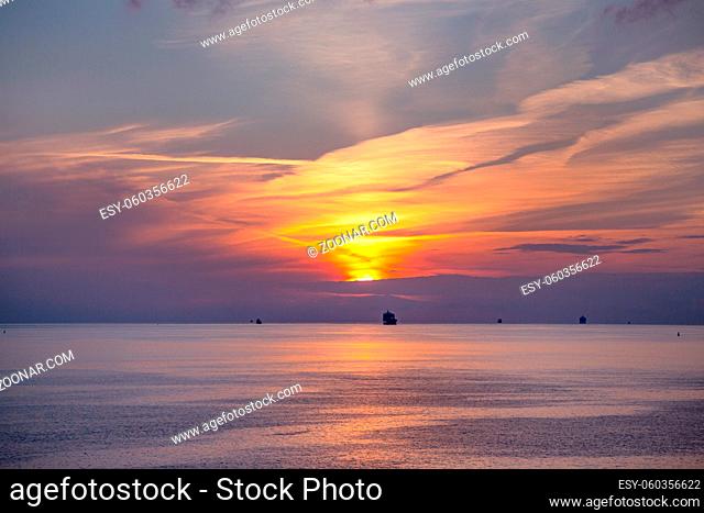 Ships in the open sea at sunset. Cruise ship on a open sea during a sunset. Incredibly beautiful sunset at sea. Dark silhouettes of ships at sunset in the open...