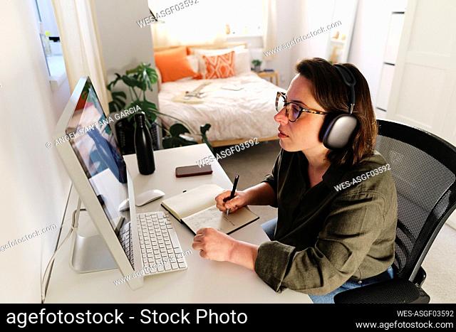 Freelancer with wireless headphones preparing strategy at home office