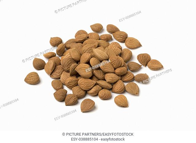 Heap of dried apricot stones isolated on white background