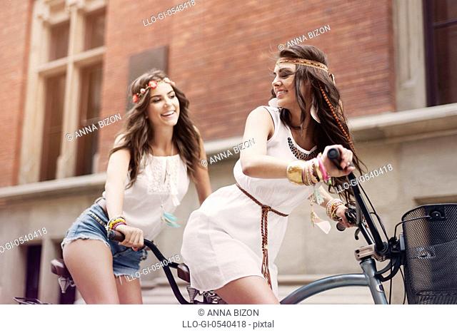 Retro portrait of two friends riding tandem bicycle. Krakow, Poland