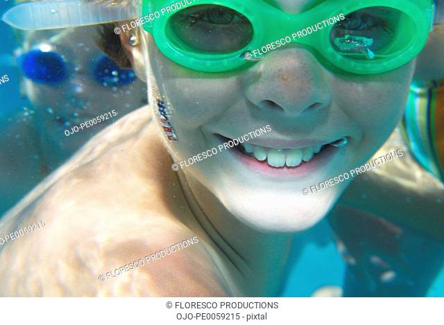 Boy and girl wearing swim goggles underwater