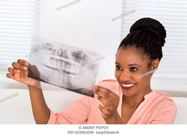 Smiling Woman Holding Her Jaw Xray Picture