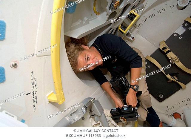 Canadian Space Agency astronaut Julie Payette, STS-127 mission specialist, stands by with a camera as she awaits the opening of the hatch that separates the...