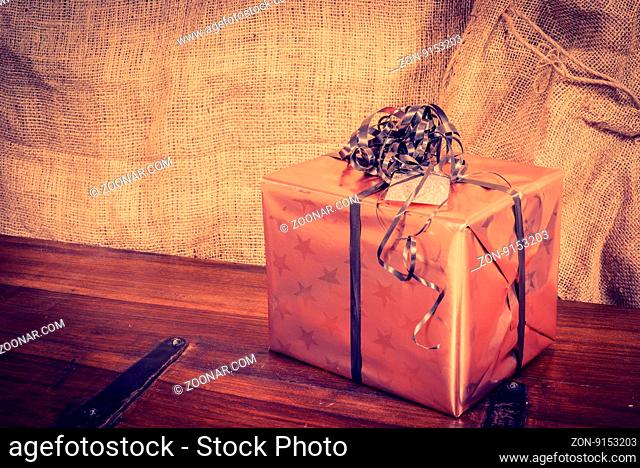 Shiny Christmas present on a dark wooden desk