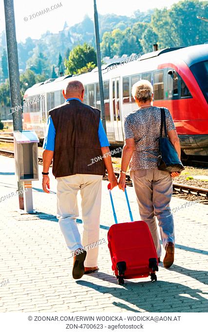 Älteres vitales Senioren Paar am Bahnhof. Reisen in den Urlaub