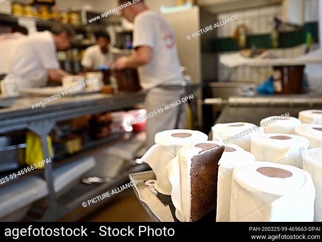 25 March 2020, North Rhine-Westphalia, Dortmund: A sliced ""toilet paper cake"" stands on a baking tray in the bakery. The round marble cake looks like toilet...