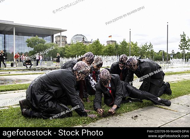 09 July 2022, Berlin: Climate protection activists of the group ""Last Generation"" dig for ""oil"" in front of the Chancellery